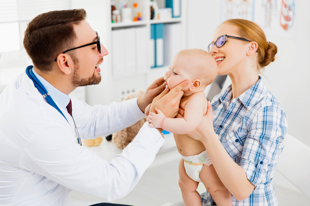 mom holding baby at first dental check up